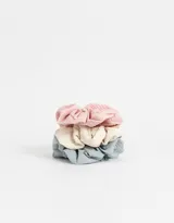 Set de tres scrunchies con textura acanalada en colores rosa, crema y celeste.