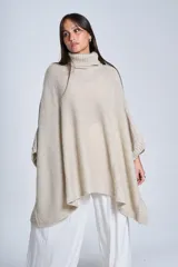 Poncho tejido color beige, con cuello alto y corte asimétrico.