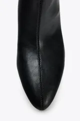 Bota de cuero sintético negro con efecto arrugado, terminación en punta y tacón fino.