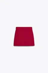 Falda mini roja de punto liso con cintura elástica y cinturón con hebilla dorada.
