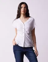 Remera blanca de lino, marca Zac & Rachel, con escote en V, abertura con botones y frunce en la parte delantera.