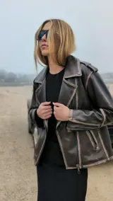 Chaqueta de cuero ovino color marrón con cierre cruzado y detalles desgastados.