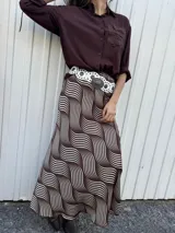 Falda larga marrón con estampado de líneas curvas blancas.