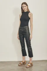 Jeans de tiro medio en poliéster, color negro, con corte acampanado y acabado brillante.