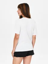 Remera color salmón con estampado de flor blanca y texto "Venice California".