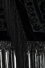 Falda midi negra de terciopelo con jacquard floral y flecos en el ruedo.