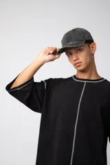 Remera negra oversize con mangas cortas y costuras a la vista en color blanco.