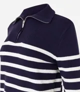 Buzo de punto grueso a rayas horizontales azul marino y blancas, con cuello alto y media cremallera frontal.