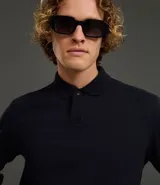 Buzo de algodón color azul marino, de manga larga y cuello polo con botones. Presenta puños y bajo ajustados.