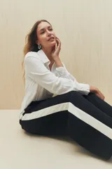 Pantalón de jogging color crema con cintura elástica, cordón ajustable y franja lateral negra.