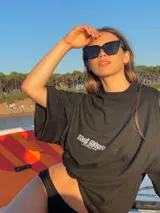 Remera color crema de corte recto y mangas cortas, con estampados en negro en el frente y la espalda.