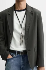 Blazer regular fit color gris oscuro, confeccionada en tejido con estructura. Cuello con solapas de muesca y manga larga. Bolsillos de solapa en cadera. Cierre frontal de botonadura.