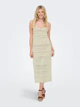 Vestido largo tejido color crudo, con escote en V, breteles finos y diseño calado.