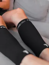 Medias de compresión deportivas negras con logo y texto en blanco.