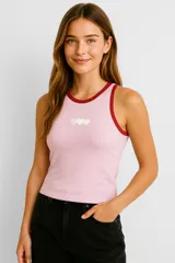 Musculosa rosa de bretel fino con cuello redondo y adorno de tres corazones blancos bordados en el frente.