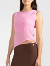 Top sin mangas color rosado, de corte asimétrico.