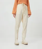 Pantalón zanahoria color crema con textura de cuadros, cordón ajustable en la cintura, bolsillos delanteros y traseros.