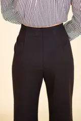 Pantalón de vestir negro con corte Oxford, tela suave al tacto con caída, cierre invisible y pinzas verticales. Confeccionado en 66% viscosa, 29% poliamida y 5% elastano.