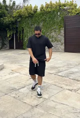 Conjunto negro tejido calado, compuesto por una remera de corte cuadrado y shorts.