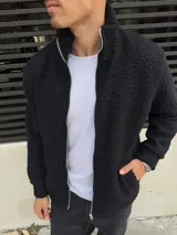 Campera negra símil corderito con cierre frontal y cuello alto.