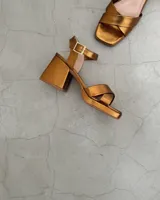 Sandalias doradas de cuero vacuno con taco bloque de 8cm y tira al tobillo.