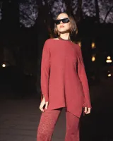 Blusa de punto en color rojo, con mangas largas y pequeñas aberturas en los laterales y puños.