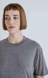 Remera gris melange de algodón premium, manga corta, cuello redondo y calce regular con recorte en la espalda.