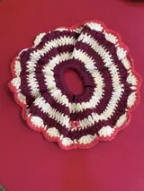 Gomita de pelo tejida al crochet con hilo de algodón a rayas en tonos rosa y violeta, con borde gris.