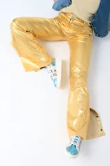 Pantalón largo de cuero sintético verde metalizado, de corte acampanado con aberturas laterales con botones a presión.