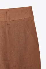 Pantalón marrón de lino, de tiro alto, con bolsillos delanteros y traseros.
