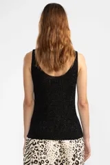 Musculosa negra de tejido de punto con lurex, escote redondo y corte ajustado.