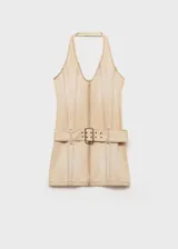 Minivestido de jean color beige, con cuello halter, cierre frontal con cremallera y cinturón con hebilla.