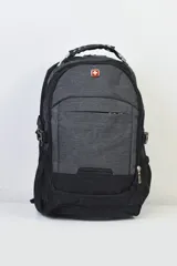 Mochila gris y negra con logo de cruz suiza en el frente. Cuenta con múltiples bolsillos y correas ajustables.