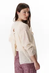 Sweater beige de tejido fino y mangas largas.