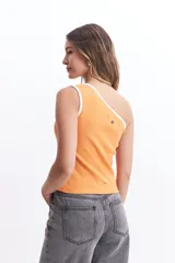 Musculosa blanca de un solo hombro con ribete negro en el borde.