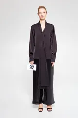 Pantalón negro de lentejuelas con cintura alta y elástica, corte amplio y bolsillos laterales.