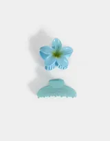 Set de dos broches para el pelo, uno con forma de flor celeste y otro con forma de pinza celeste con glitter.
