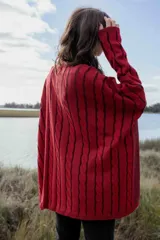 Sweater color crema de tejido de punto trenzado, con cuello redondo y mangas largas.