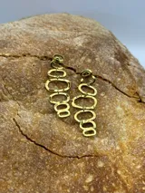 Par de aros colgantes dorados con forma de eslabones ovalados.