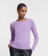 Suéter de punto color lila, con cuello barco, mangas largas con puños acanalados y detalle de botones en los puños.