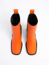 Botín negro de cuero, con punta cuadrada, caña media y elásticos laterales. Taco cuadrado de 7,5 cm.