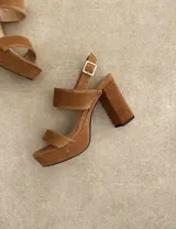 Sandalias de plataforma color marrón, con dos tiras anchas en el empeine y tobillo con hebilla dorada.