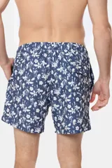 Short de baño celeste con estampado de flores blancas, cintura elástica con cordón ajustable, bolsillos laterales y suspensor de malla fina.
