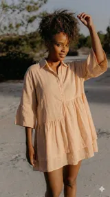 Vestido celeste de corte suelto, con cierre frontal de botones, mangas largas arremangables y falda con frunces.