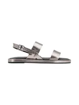 Sandalias plateadas de cuero con doble tira, pulsera de ajuste con hebilla metálica y suela plana.