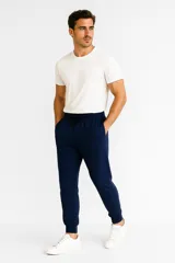 Pantalón de jogging azul marino con cintura elástica ajustable con cordón, bolsillos laterales y puños ajustados en los tobillos.
