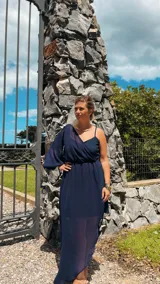 Vestido largo azul marino con un hombro descubierto, manga larga abullonada y falda irregular con sobrevestido de crepé.