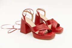 Sandalias rojas de cuero con plataforma y tiras para atar al tobillo.