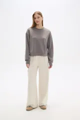 Pantalón negro de poliéster, de calce alto y corte ancho, con bolsillos laterales y cintura elástica.