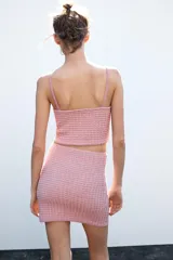 Minifalda rosa de tejido texturizado con tiro alto y corte ajustado.